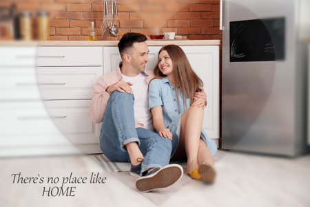 Happy couple sitting on floor in kitchenの写真素材
