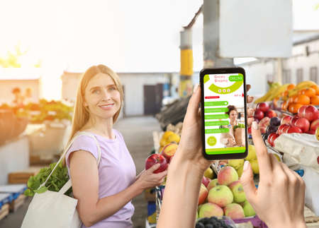Woman choosing fruits at market. Concept of buying products online