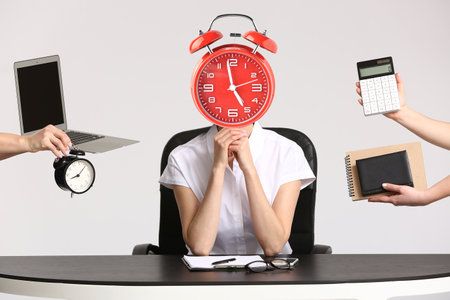 Young secretary with alarm clock instead of head and a lot of work at table in office. Time management conceptの写真素材