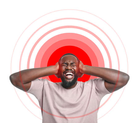 Handsome African-American man suffering from head ache on white background