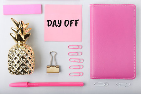 Composition with text DAY OFF, golden pineapple and stationery on light background