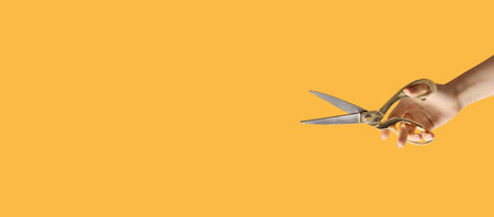 Woman holding tailor's scissors on color background with place for textの写真素材