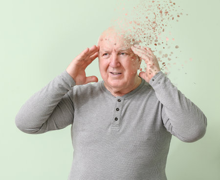 Elderly man suffering from mental disability on color backgroundの写真素材