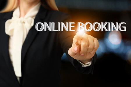 Young businesswoman using virtual screen for online booking on dark backgroundの写真素材