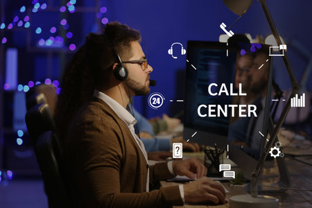Technical support agents working in office at nightの写真素材