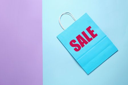 Paper shopping bag with word "Sale" on color backgroundの写真素材