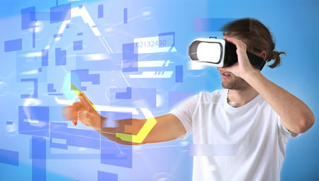 Young man with VR glasses on color background