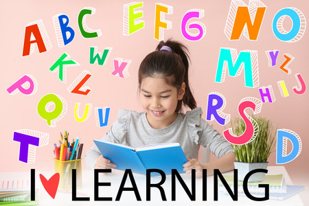 Text I LOVE LEARNING and little Asian girl doing homework at table