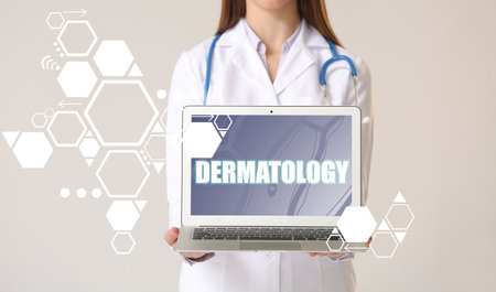 Dermatologist with laptop on light background. Concept of telemedicineの写真素材