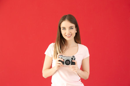 Young female photographer on color backgroundの写真素材