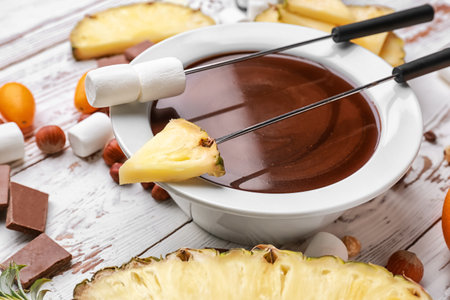 Bowl with tasty chocolate fondue, marshmallow and fruits on tableの写真素材