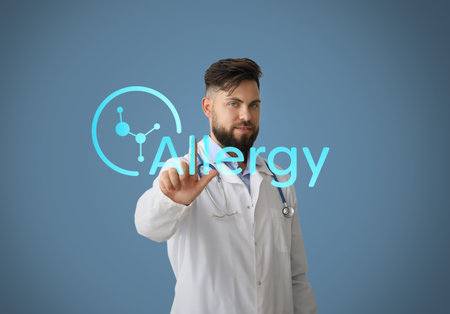 Male doctor pointing at word ALLERGY on color backgroundの写真素材