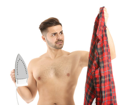Stressed young man with iron and clothes on white backgroundの写真素材