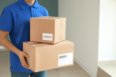Delivery man with boxes indoorsの写真素材