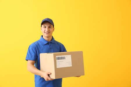 Delivery man with box on color background