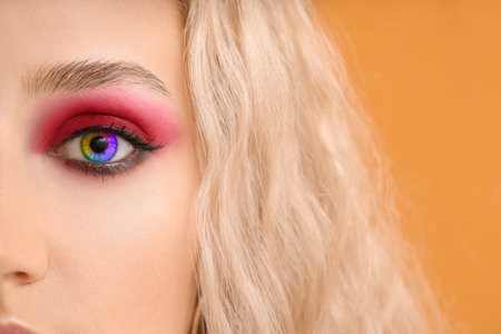 Beautiful young woman with unusual makeup wearing rainbow contact lenses, closeupの写真素材