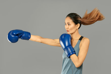 Female Asian boxer on gray backgroundの写真素材