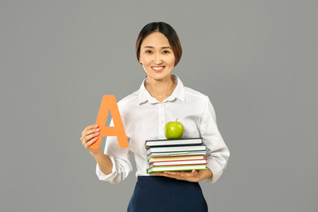 Female Asian teacher on gray backgroundの写真素材