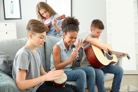 Teenage musicians playing and singing at homeの写真素材