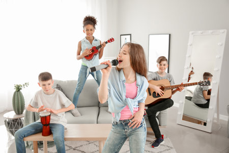 Teenage musicians playing and singing at homeの写真素材