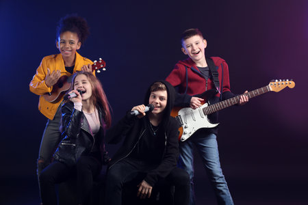 Band of teenage musicians on dark backgroundの写真素材
