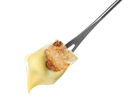 Fondue stick with cheese covered piece of bread on white backgroundの写真素材