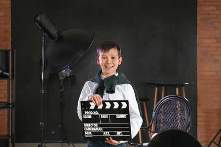 Little film director with clapperboard in studioの写真素材