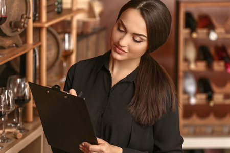 Female sommelier working in wine cellarの写真素材