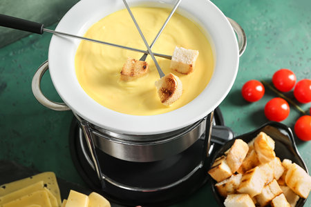 Cheese fondue with croutons on tableの写真素材