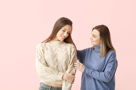 Portrait of happy mother and daughter on color backgroundの写真素材