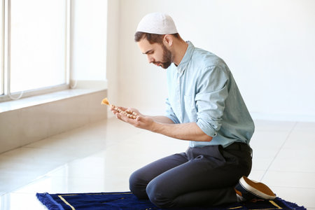 Young Muslim man praying indoorsの写真素材