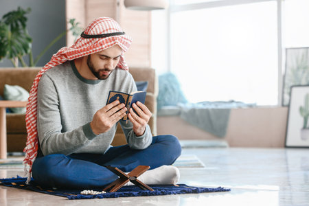 Young Muslim man praying indoors