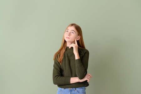 Thoughtful teenage girl on color backgroundの写真素材
