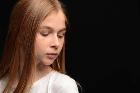 Sad teenage girl on dark background