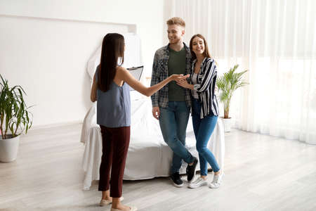 Real estate agent showing young couple a new houseの写真素材