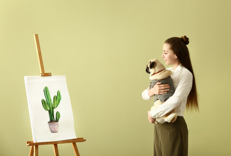 Teenage artist with cute pug dog at homeの写真素材