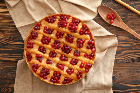 Tasty cranberry pie on table