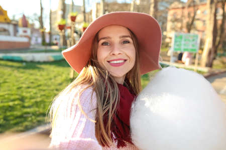 Woman taking selfie with sweet cotton candy outdoors