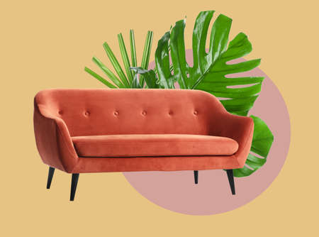 Stylish sofa on color background with tropical leaves