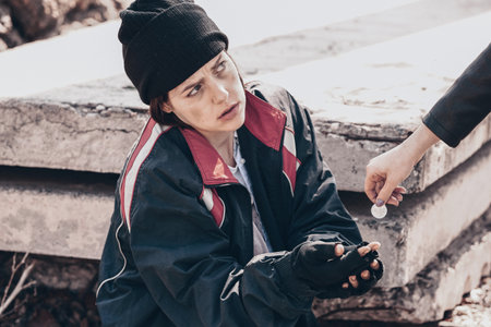 Passer-by giving money to poor homeless woman outdoorsの写真素材