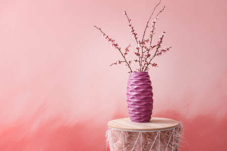 Vase with beautiful blossoming branches on table
