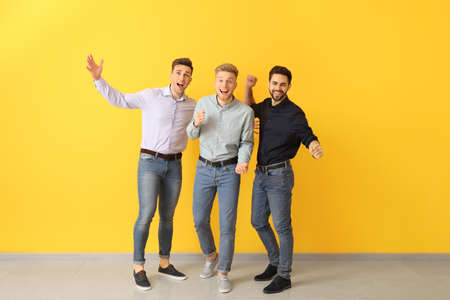 Happy young men near color wall