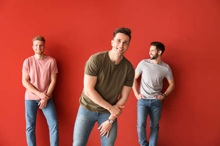 Fashionable young men on color backgroundの写真素材