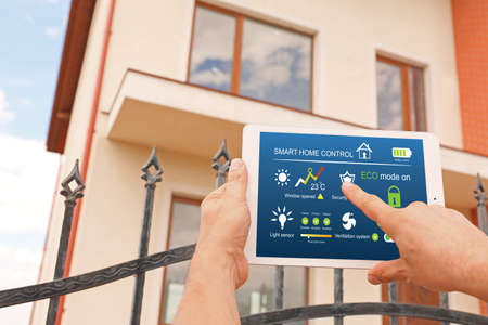 Man using application of smart home automation near house outdoorsの写真素材