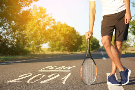 Sporty young man with tennis racket outdoors. Concept of goal achievementの写真素材
