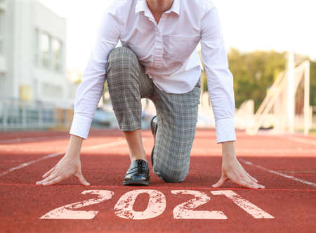 Young businesswoman in crouch start position at the stadium Concept of goal achievement