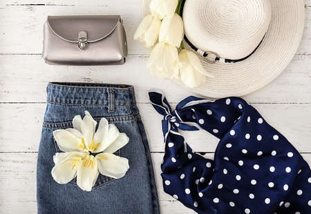 Female clothes and accessories with flowers on white wooden backgroundの写真素材