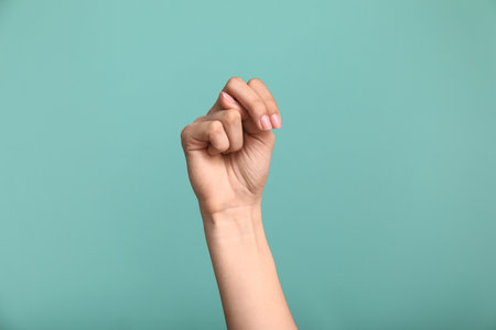 Female hand showing letter N on color backgroundの写真素材