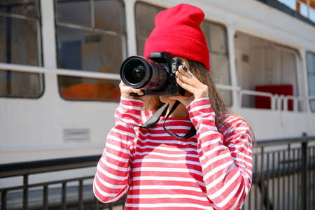 Young female photographer on embankment