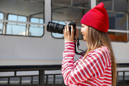 Young female photographer on embankment